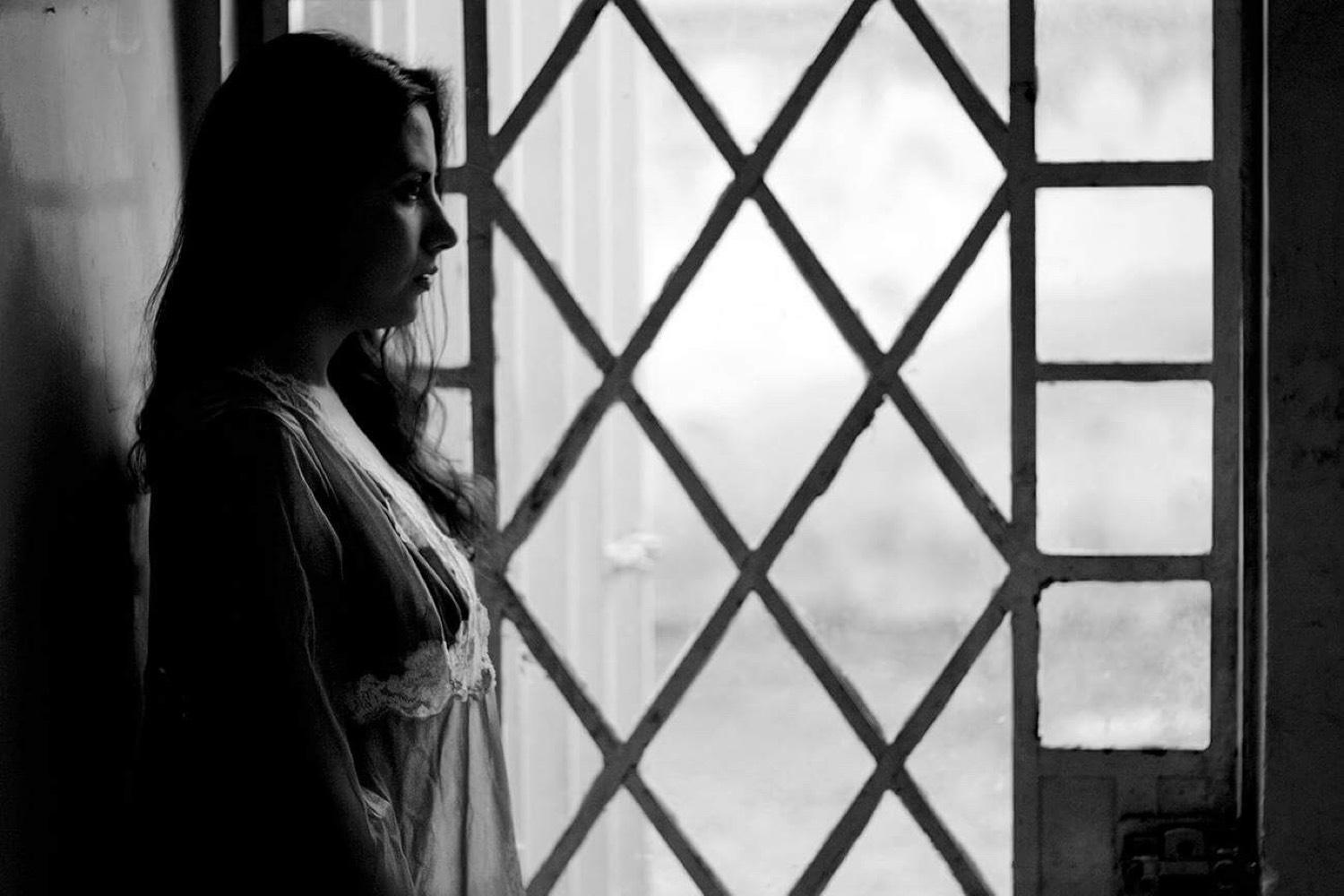 Silueta junto a una ventana de rombos