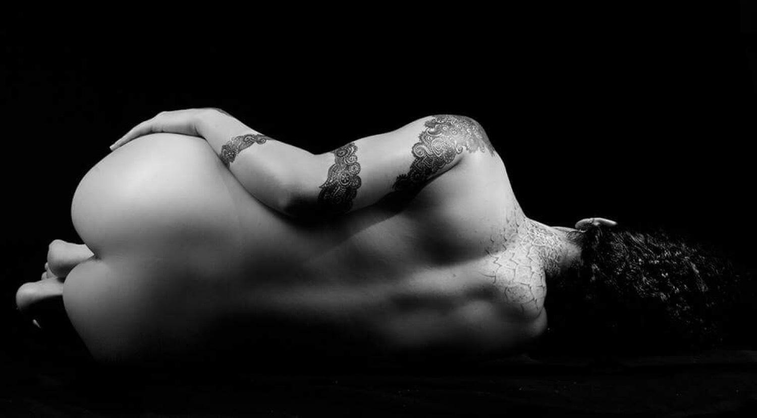 Figura recostada con tatuajes, blanco y negro
