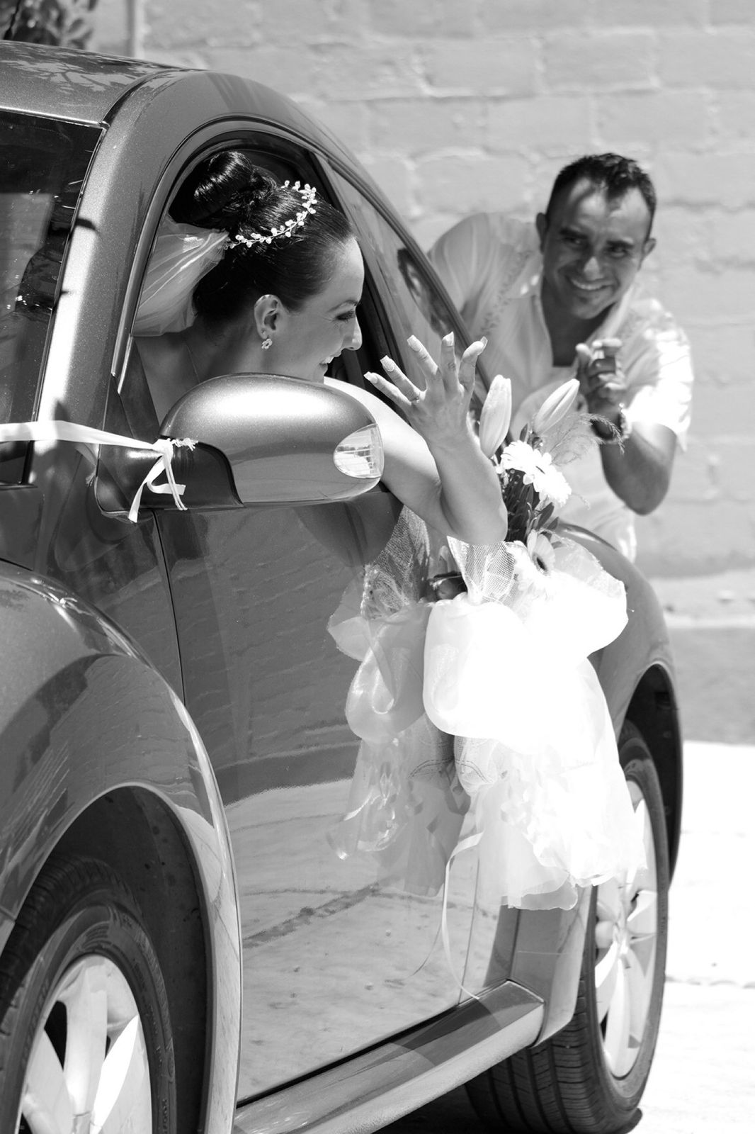 La novia en el coche, el novio aplaude, blanco y negro