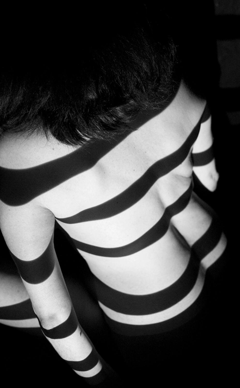 Cuerpo en blanco y negro con sombras de rayas