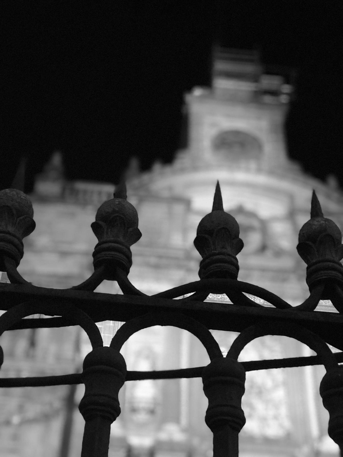 Reja de hierro frente a un edificio de noche