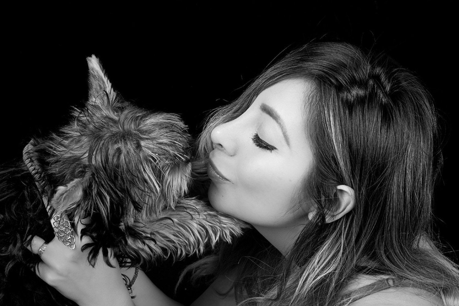 Mujer recibiendo un beso de un yorkshire terrier, blanco y negro