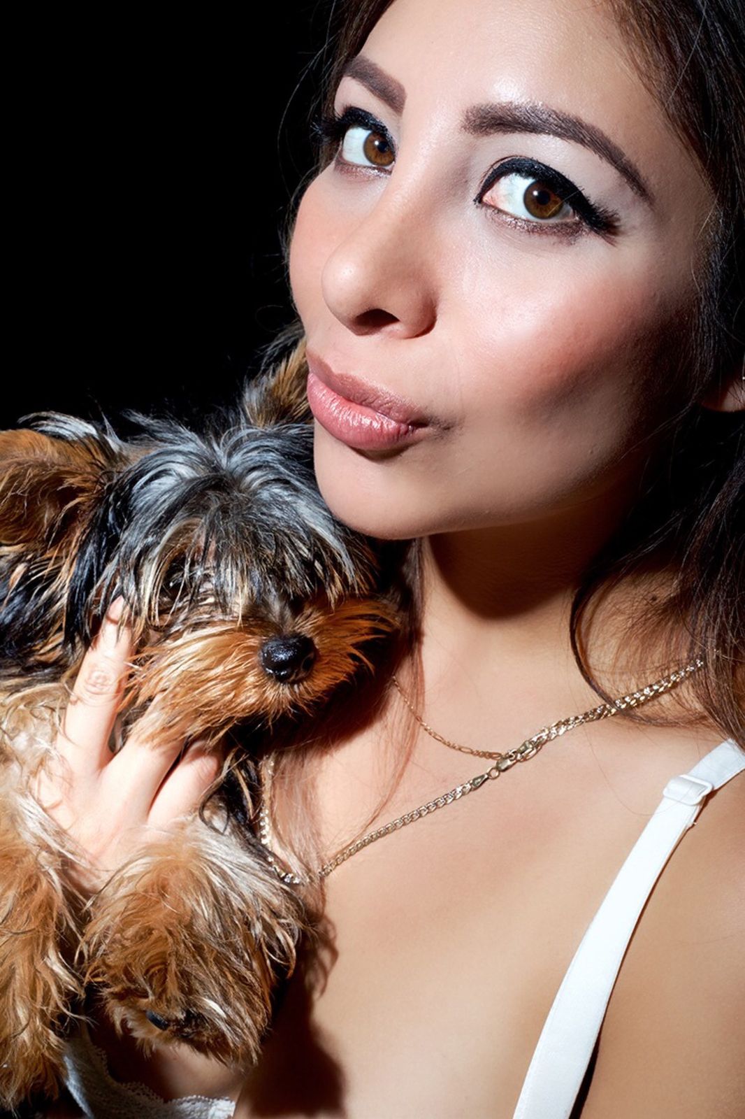 Mujer con un yorkshire terrier apoyado en el hombro