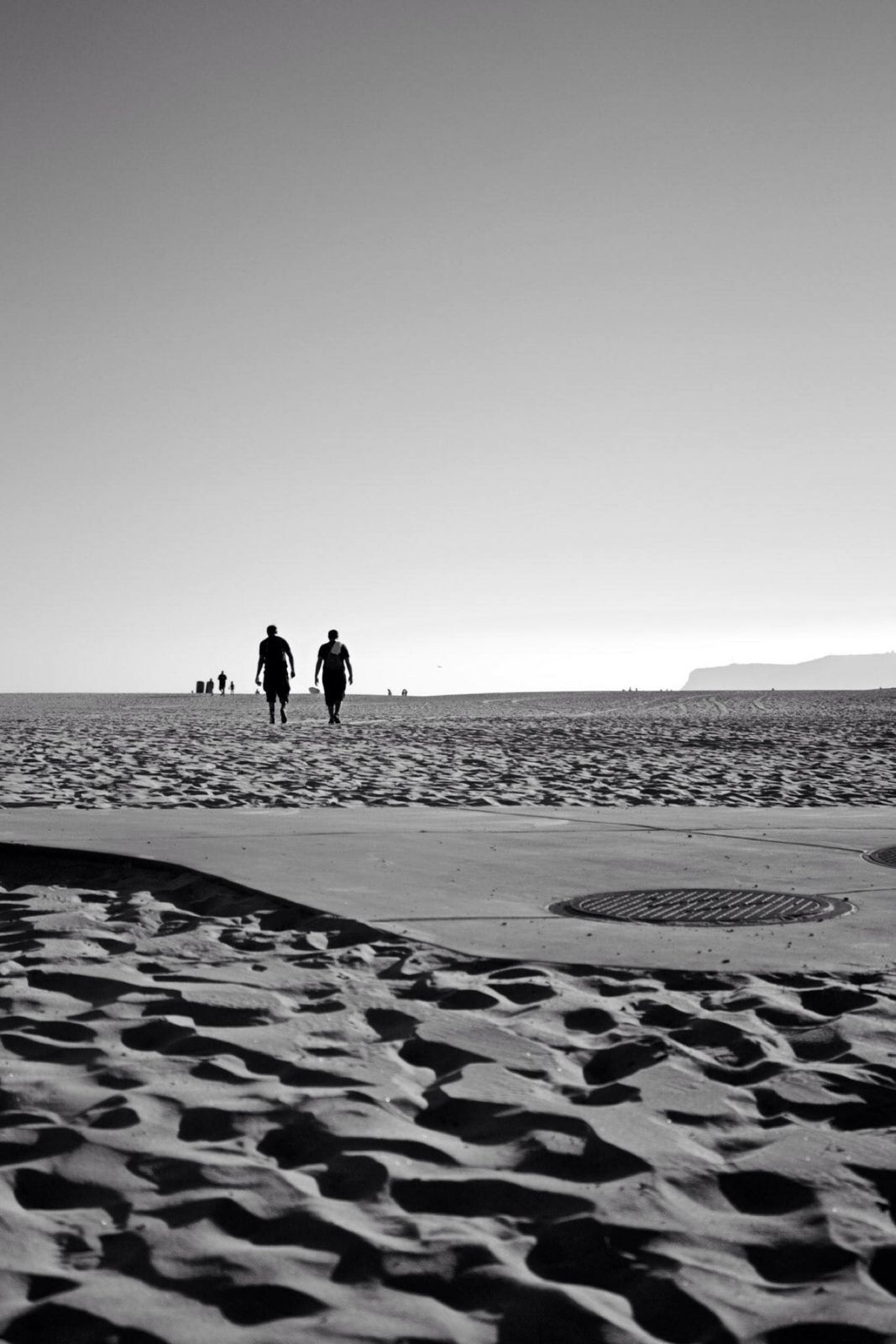 Dos figuras caminando en la playa