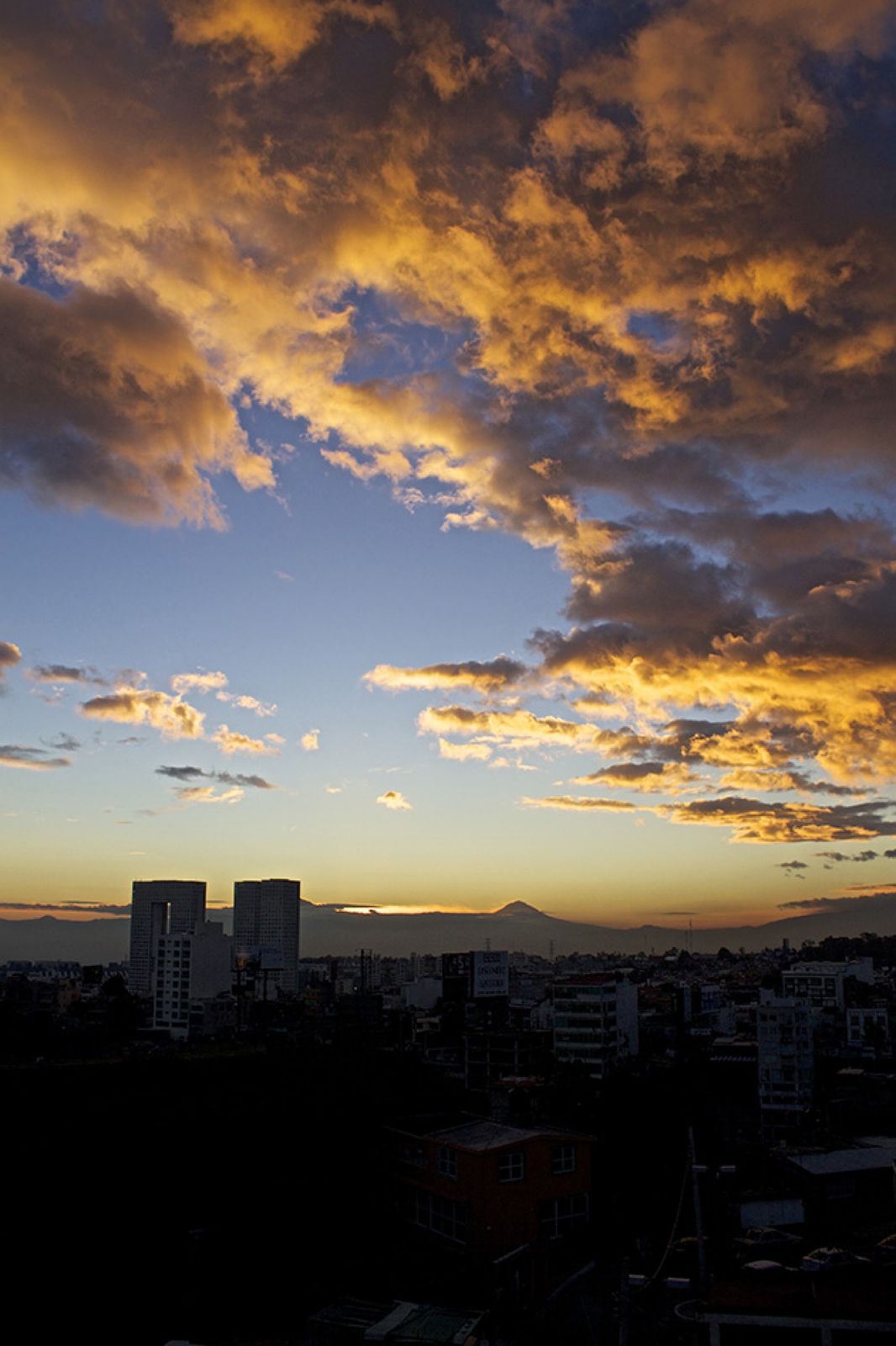 Atardecer sobre la ciudad con el volcán al fondo