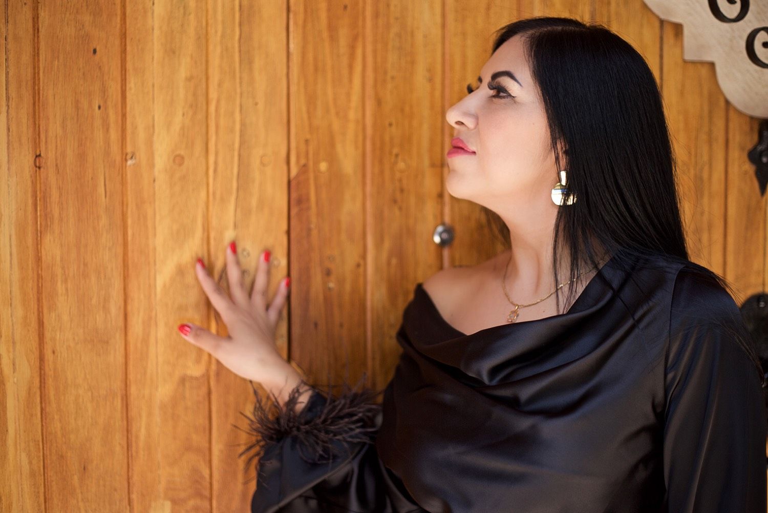 Retrato de perfil junto a una puerta de madera