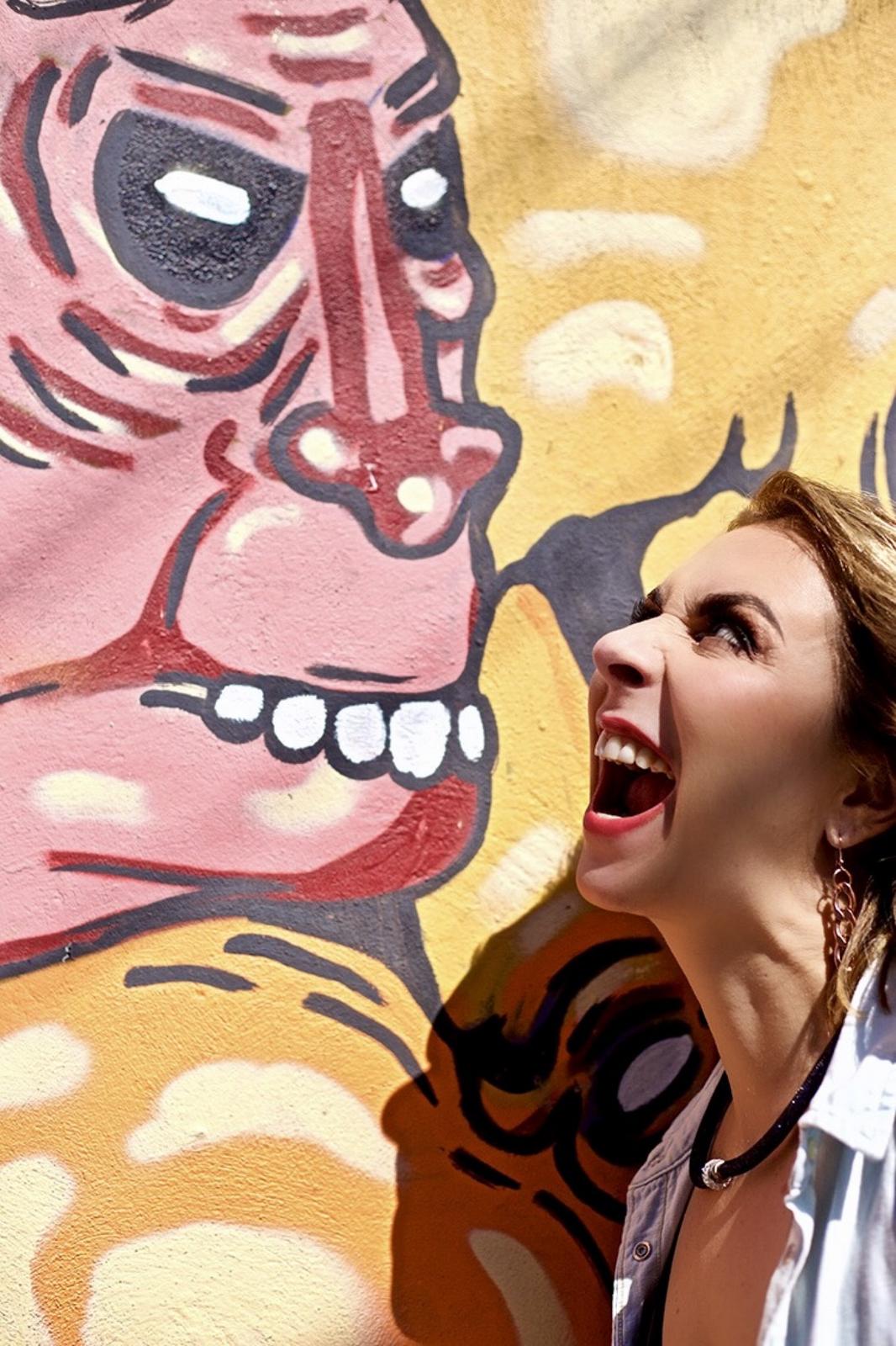 Retrato junto a un mural